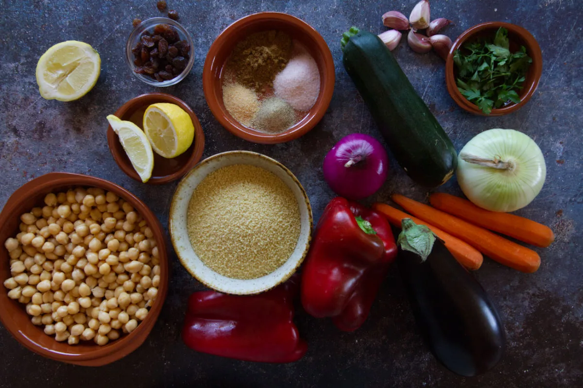 A colorful array of ingredients used to make Moroccan couscous are laid out on a table. 