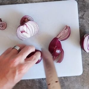 some red onion is chopped on a white board.