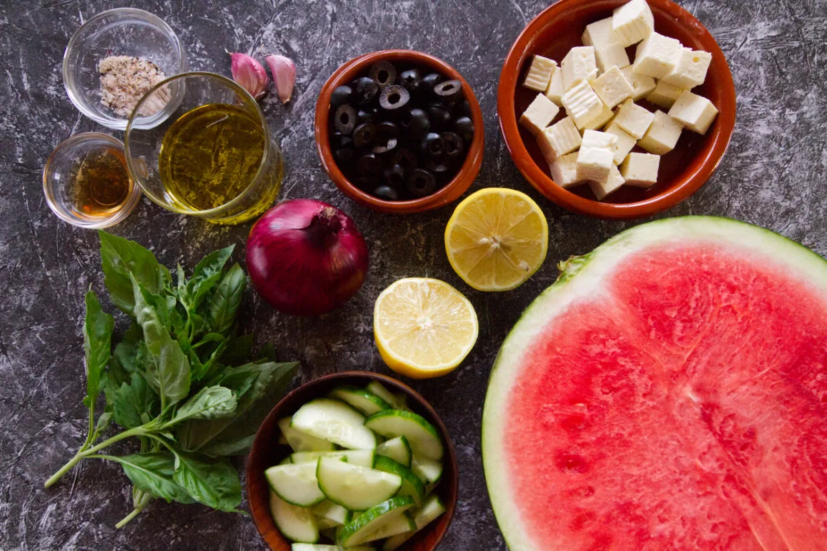 Ingredients to make a watermelon salad are laid out on a table