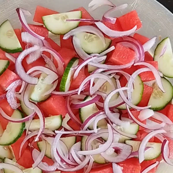watermelon, cucumber, and red onion on a large plate.