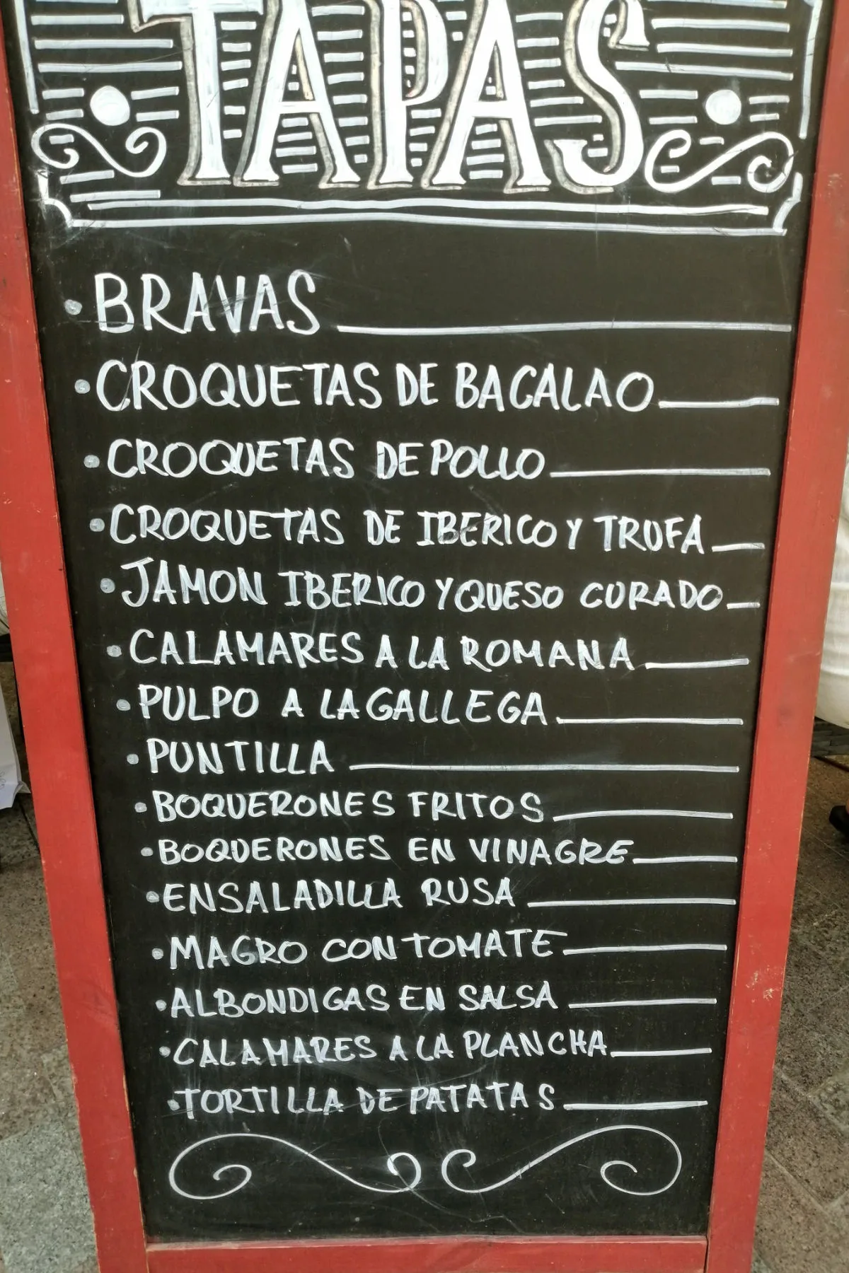 A restaurant sign advertising various tapas dishes