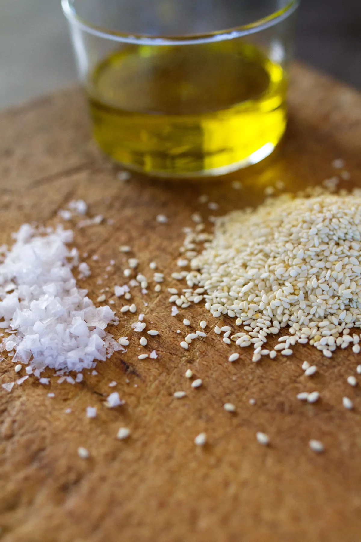 sesame seeds, salt, and olive oil sit on a counter