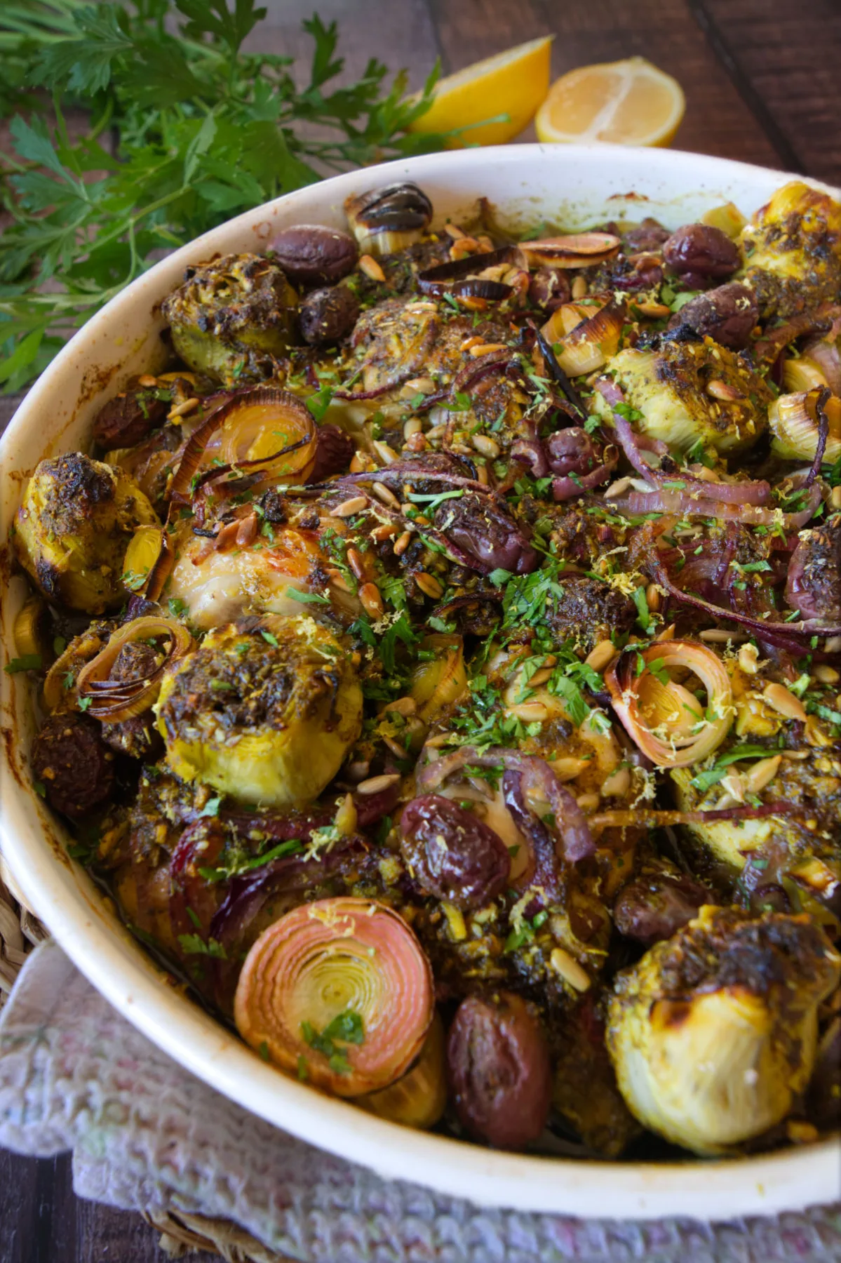 A large dish of Za'atar chicken with leeks, and roasted artichoke hearts.