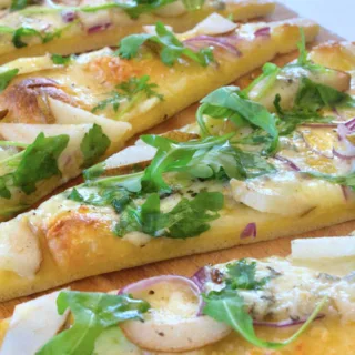 slices of Gorgonzola pizza topped with rocket.