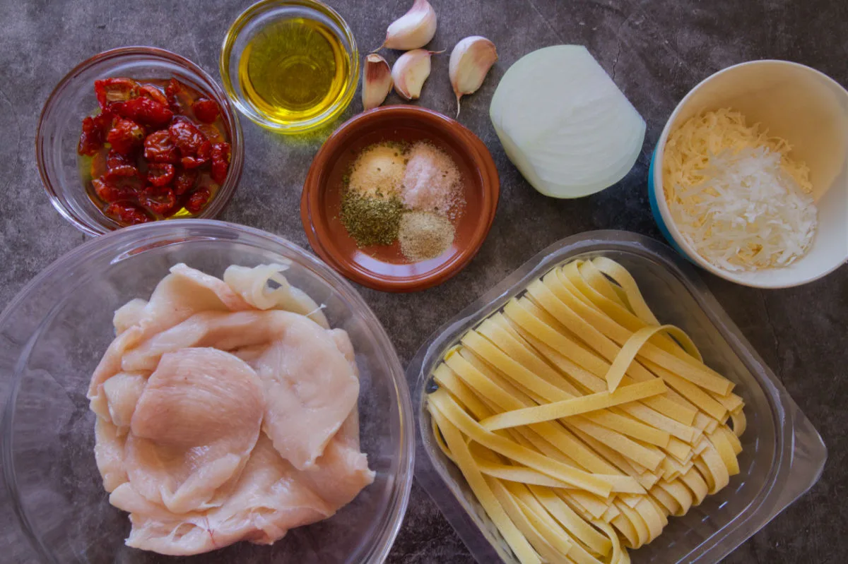 Ingredients to make chicken tagliatelle pasta are laid out on a counter top.