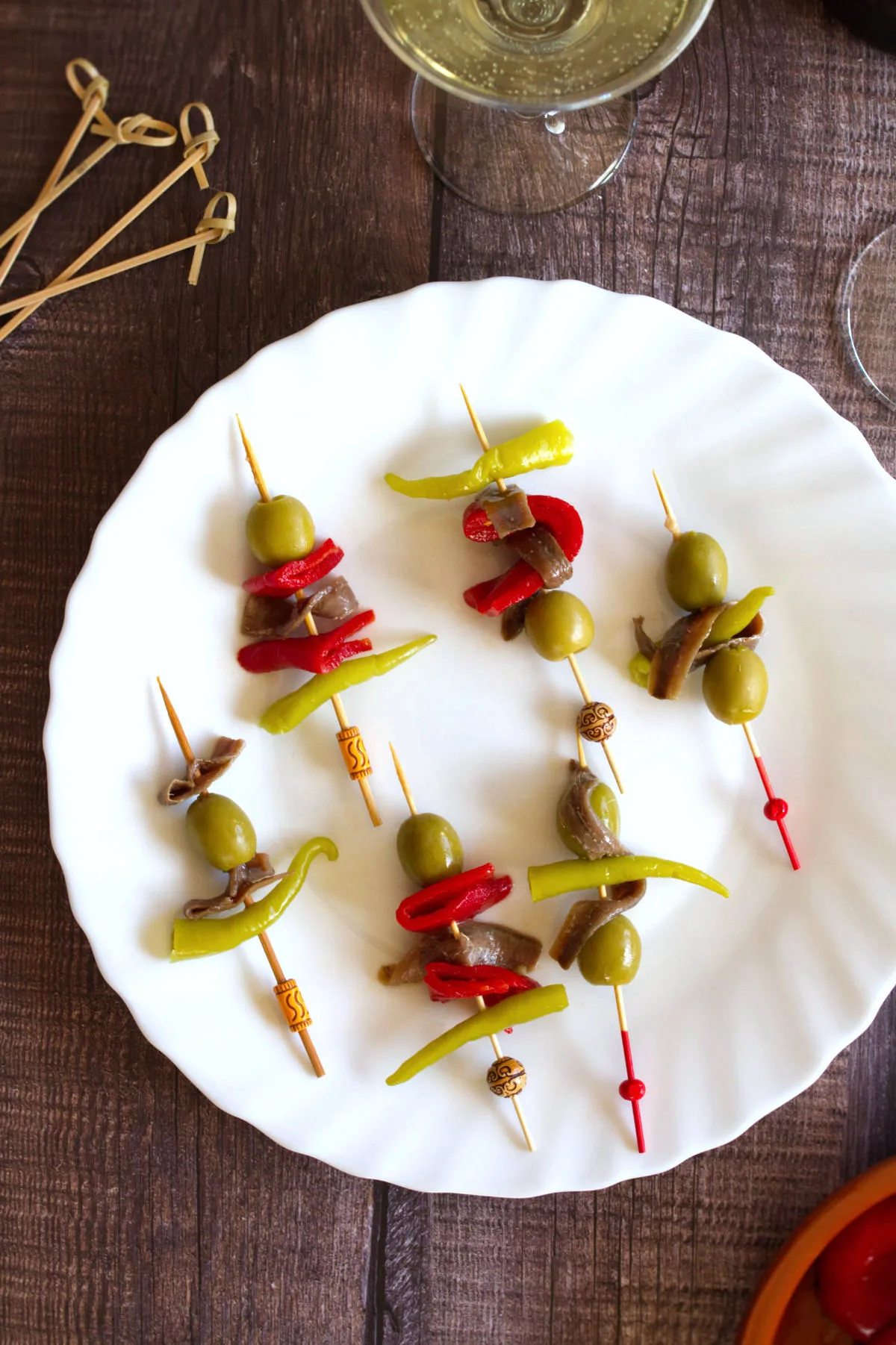 A selection of banderillas on a plate — ingredients like roasted peppers and olives on a toothpick as a snack or a tapas.