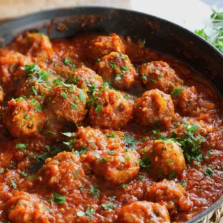 a pan of Spanish meatballs in a rich tomato sofrito sauce.