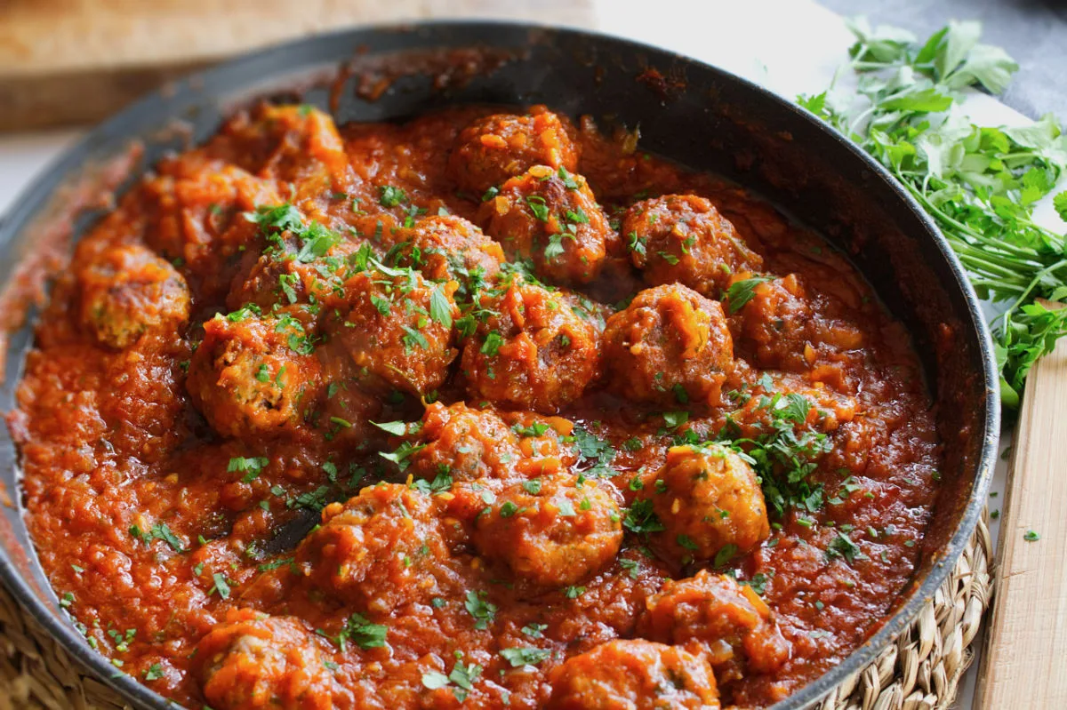 a pan of Spanish meatballs in a rich tomato sofrito sauce.