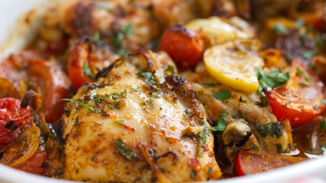 A large dish of baked Mediterranean chicken thighs