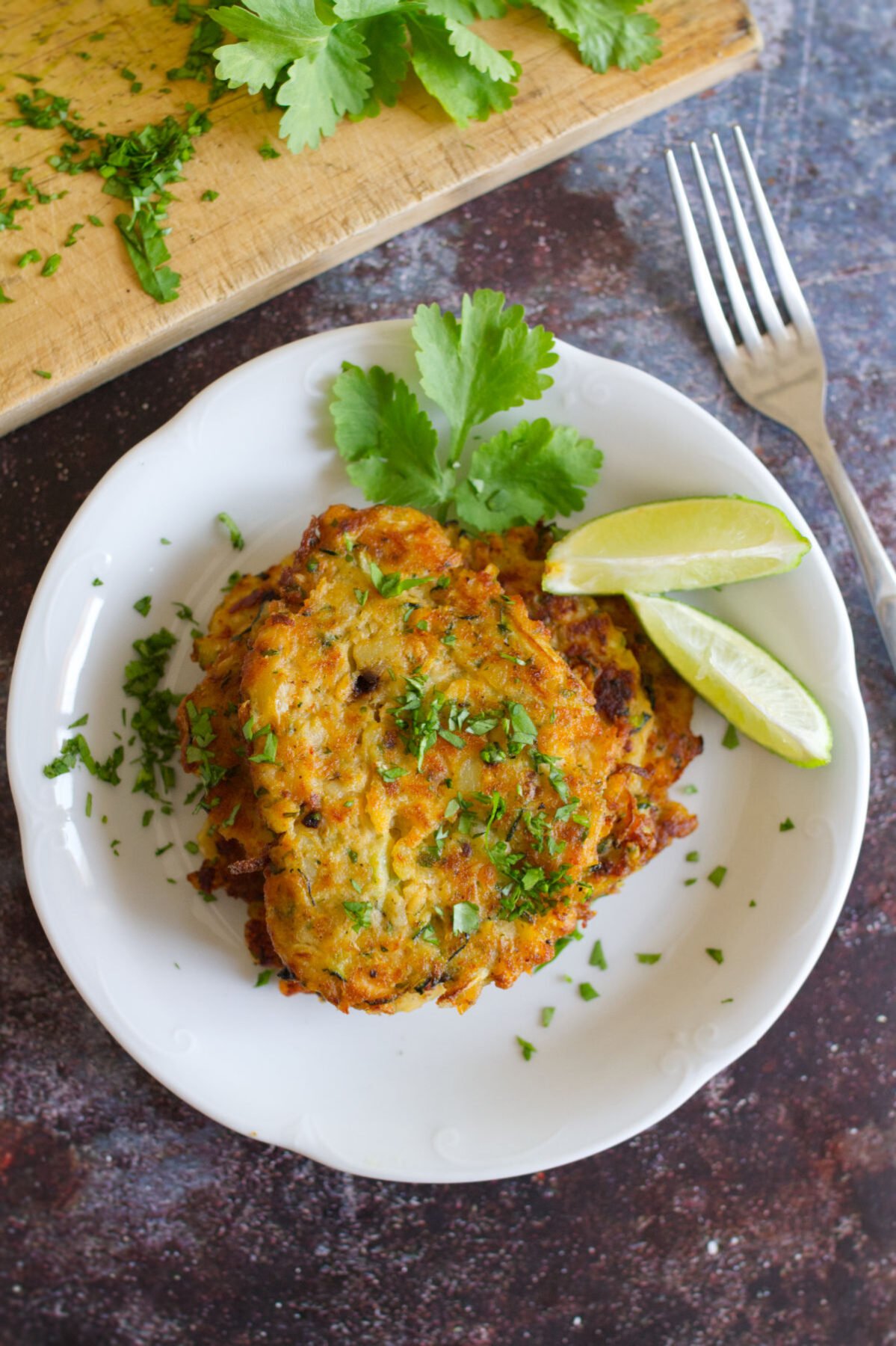 A stack of salmon fishcakes with cilantro and lime.