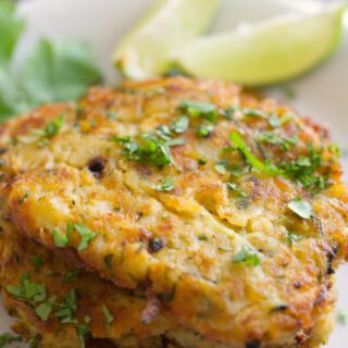 A stack of salmon fishcakes with cilantro and lime.