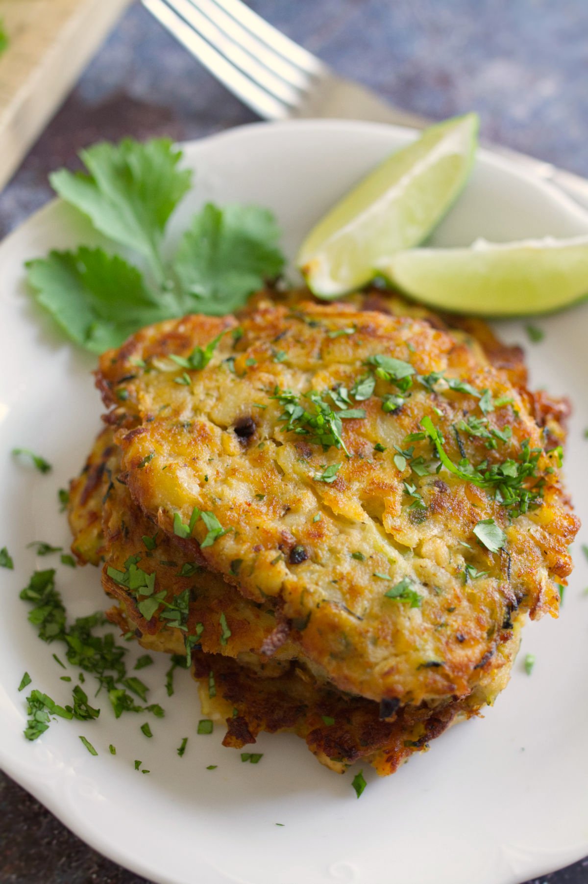 A stack of salmon fishcakes with cilantro and lime. 