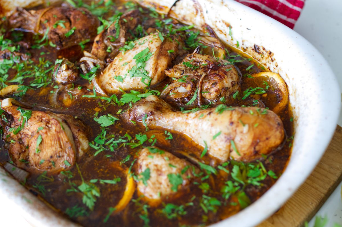 A large dish of balsamic chicken with lemon with. some fresh chopped parsley as a garnish