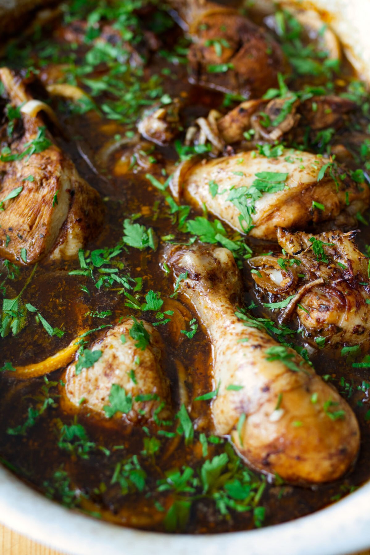 A large dish of balsamic chicken with lemon with. some fresh chopped parsley as a garnish