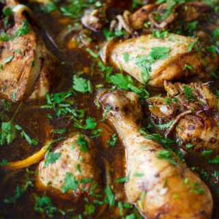 A large dish of balsamic chicken with lemon with. some fresh chopped parsley as a garnish