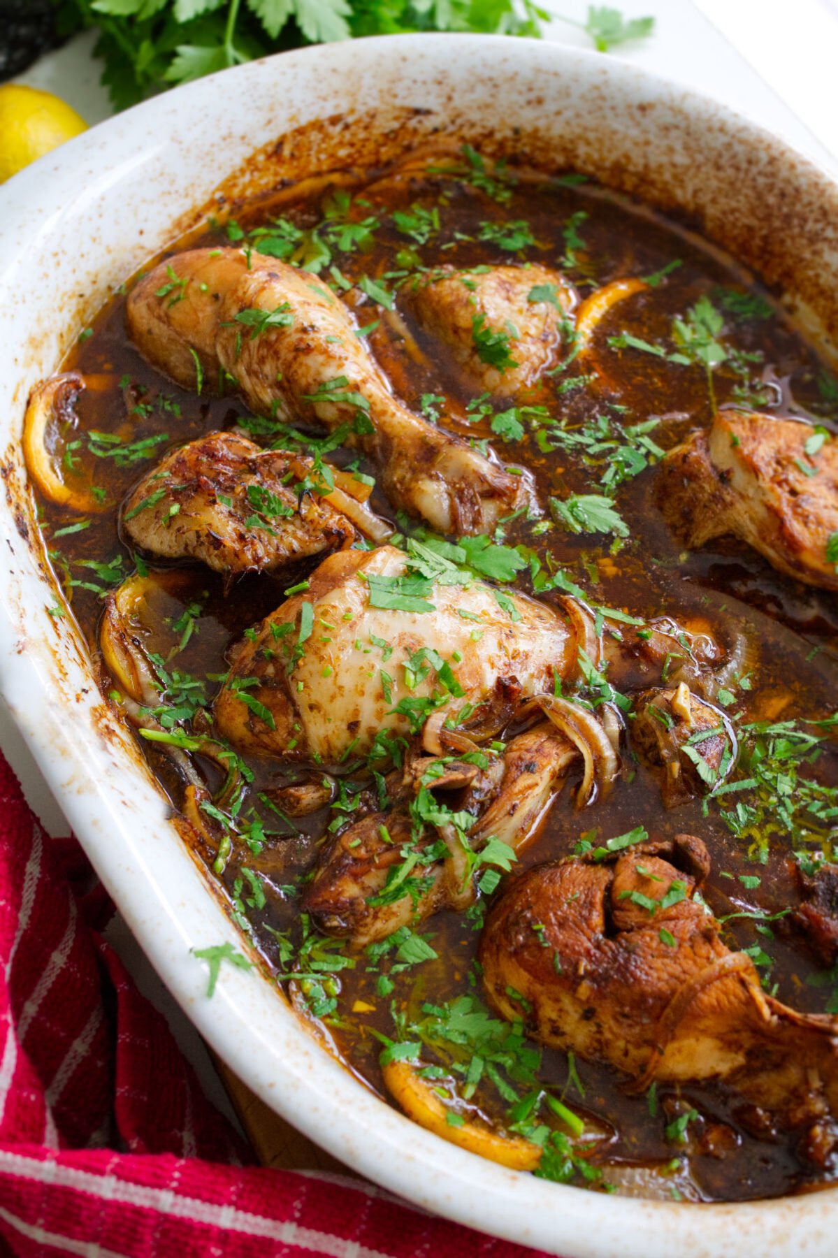 A large dish of balsamic chicken with lemon with. some fresh chopped parsley as a garnish