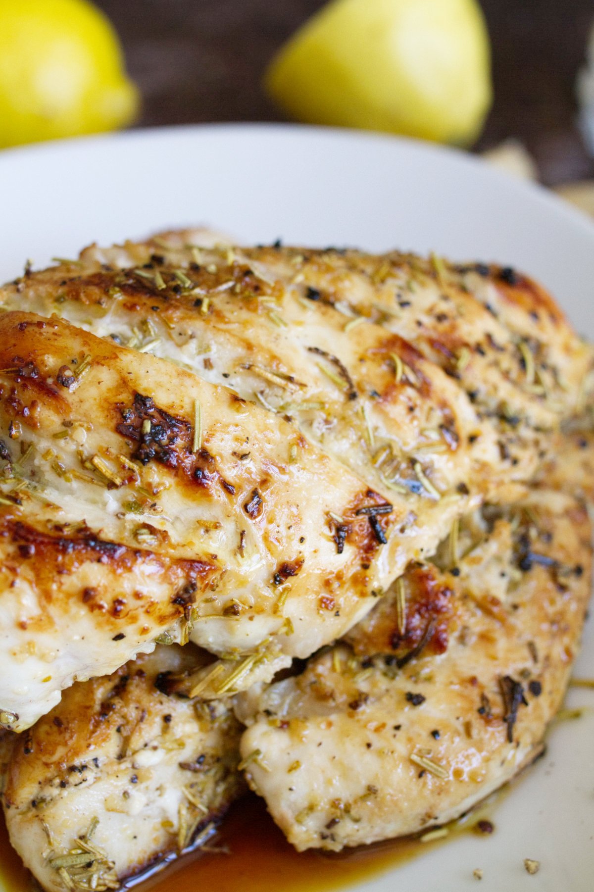 A cooked marinated chicken breast sits in a bowl.