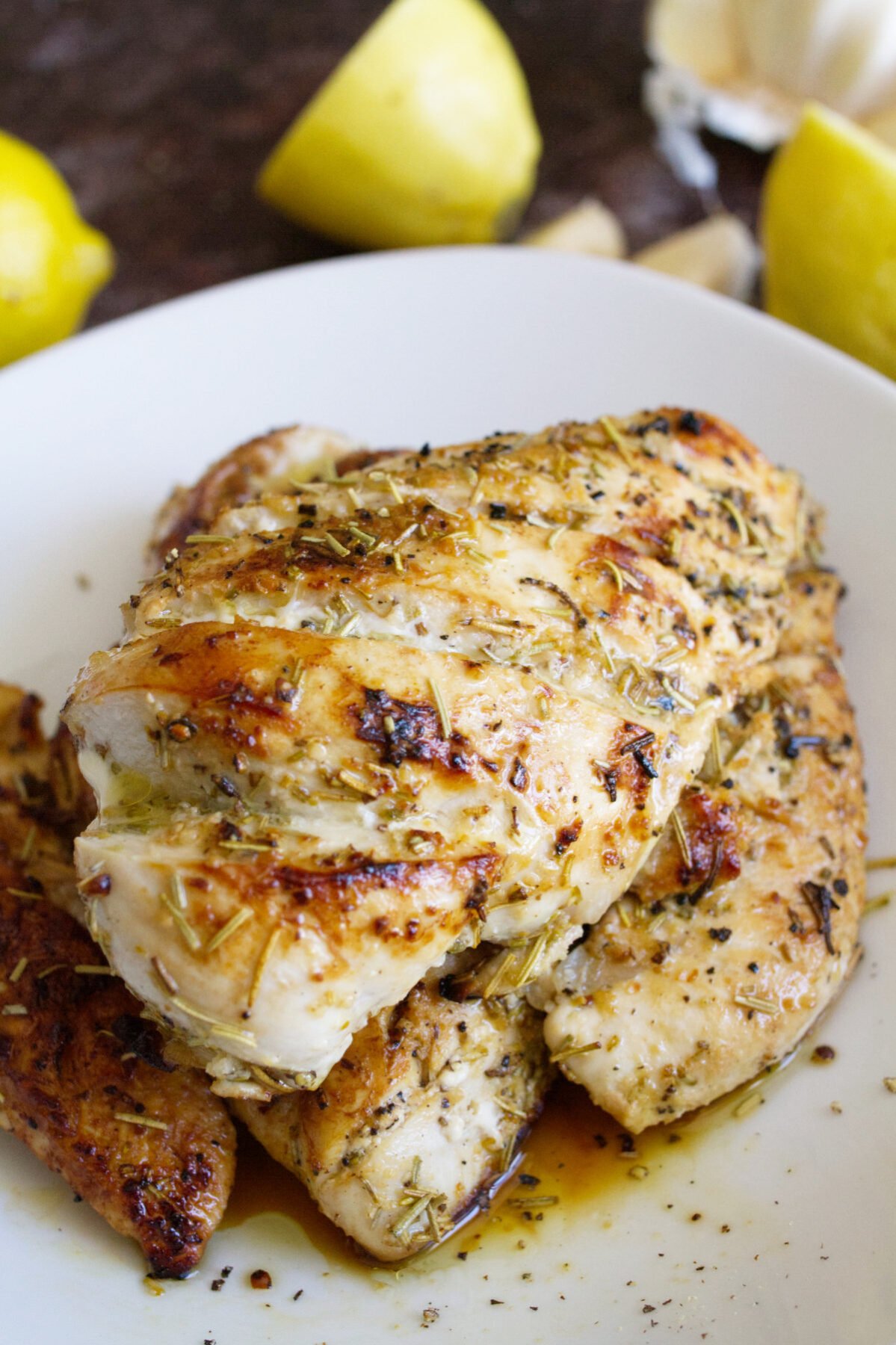 A cooked marinated chicken breast sits in a bowl.