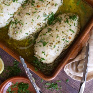 Mediterranean chicken breasts in a casserole dish.