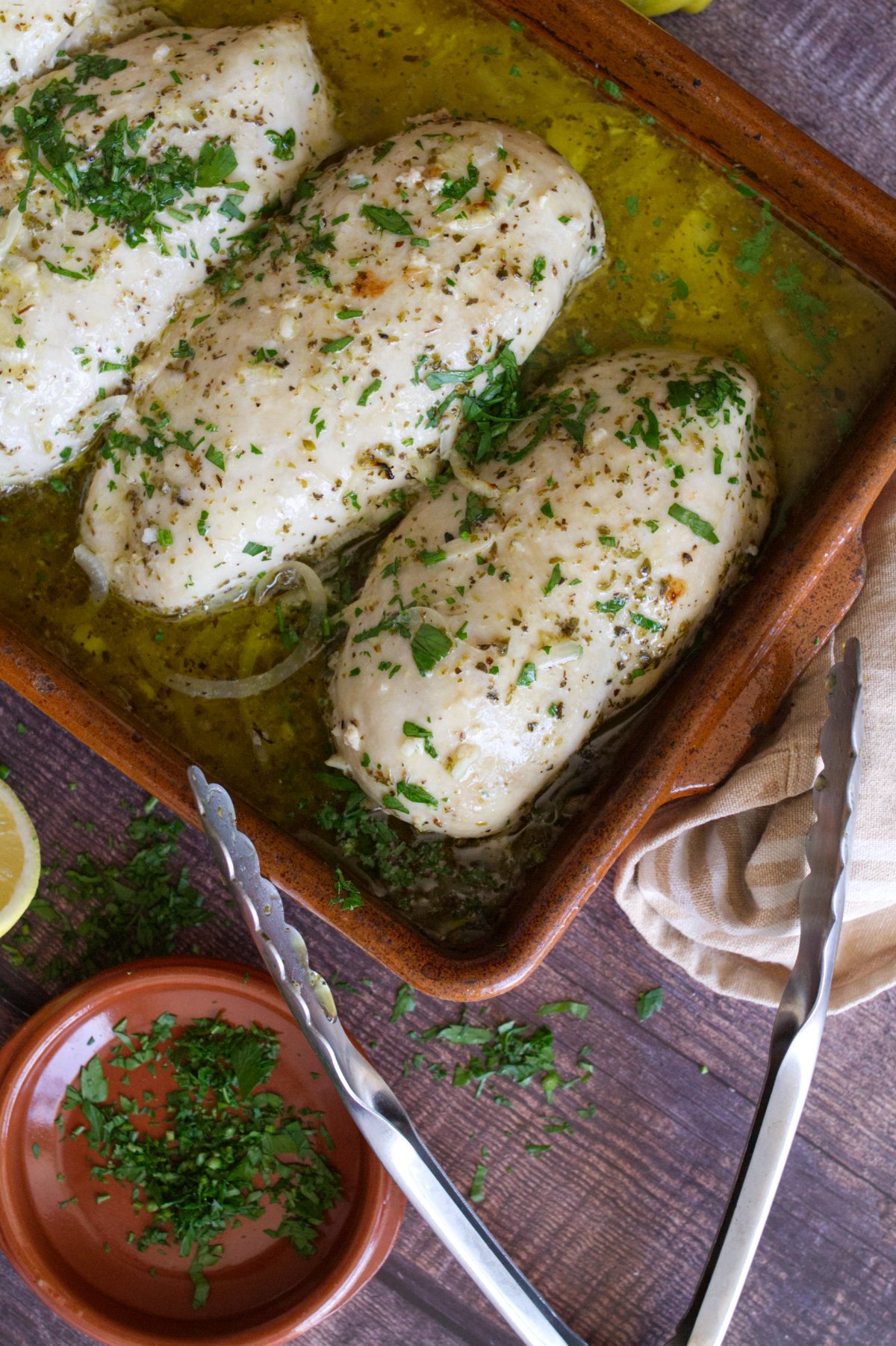 Mediterranean chicken breasts in a casserole dish.