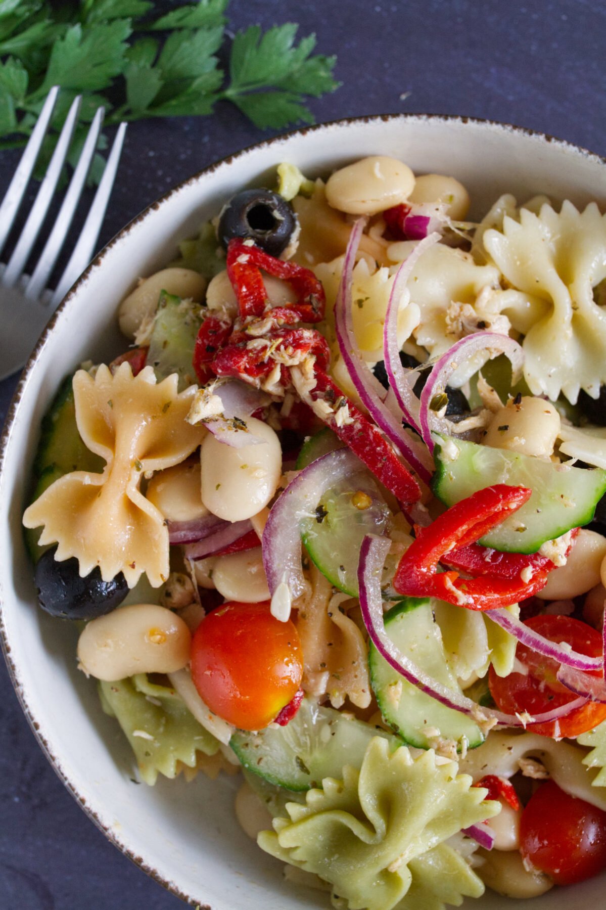 A large bowl of mediterranean pasta salad with tuna