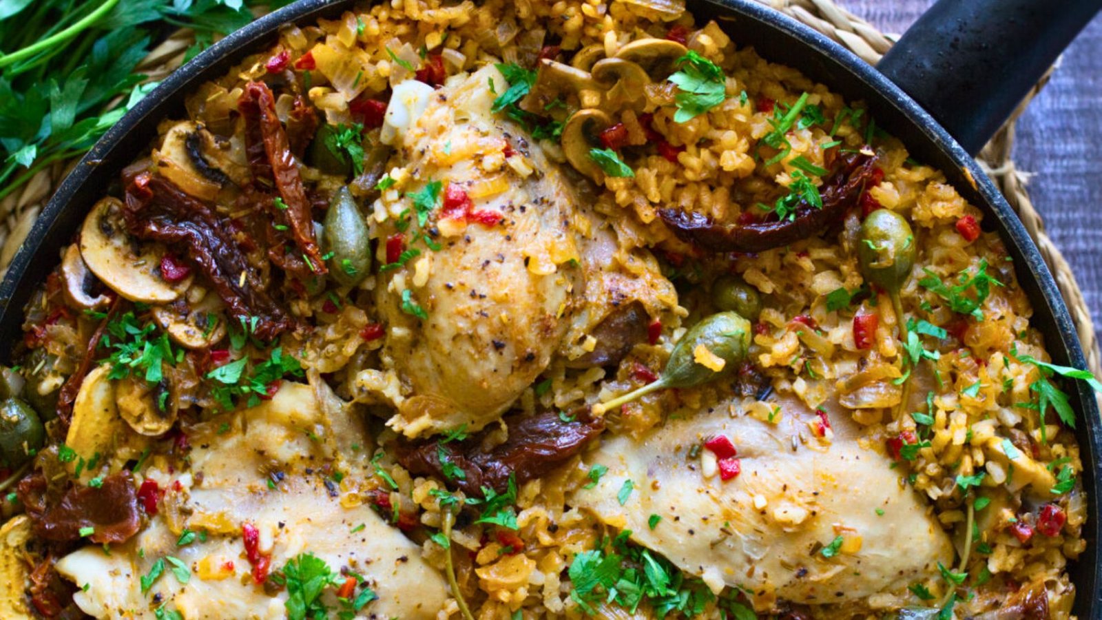 A large pan of Italian Chicken thighs with lots of rice.