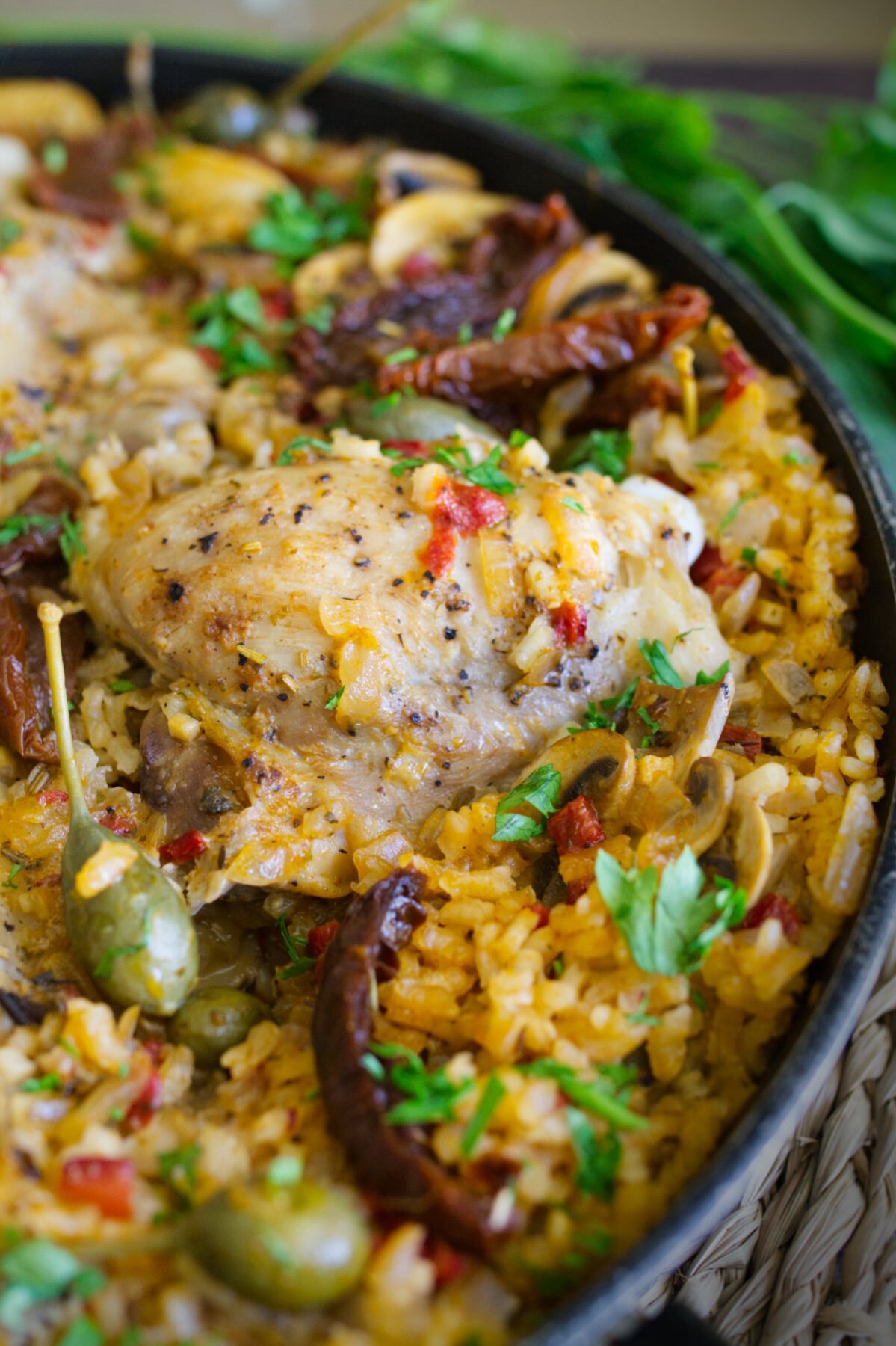 A large pan of Italian Chicken thighs with lots of rice.