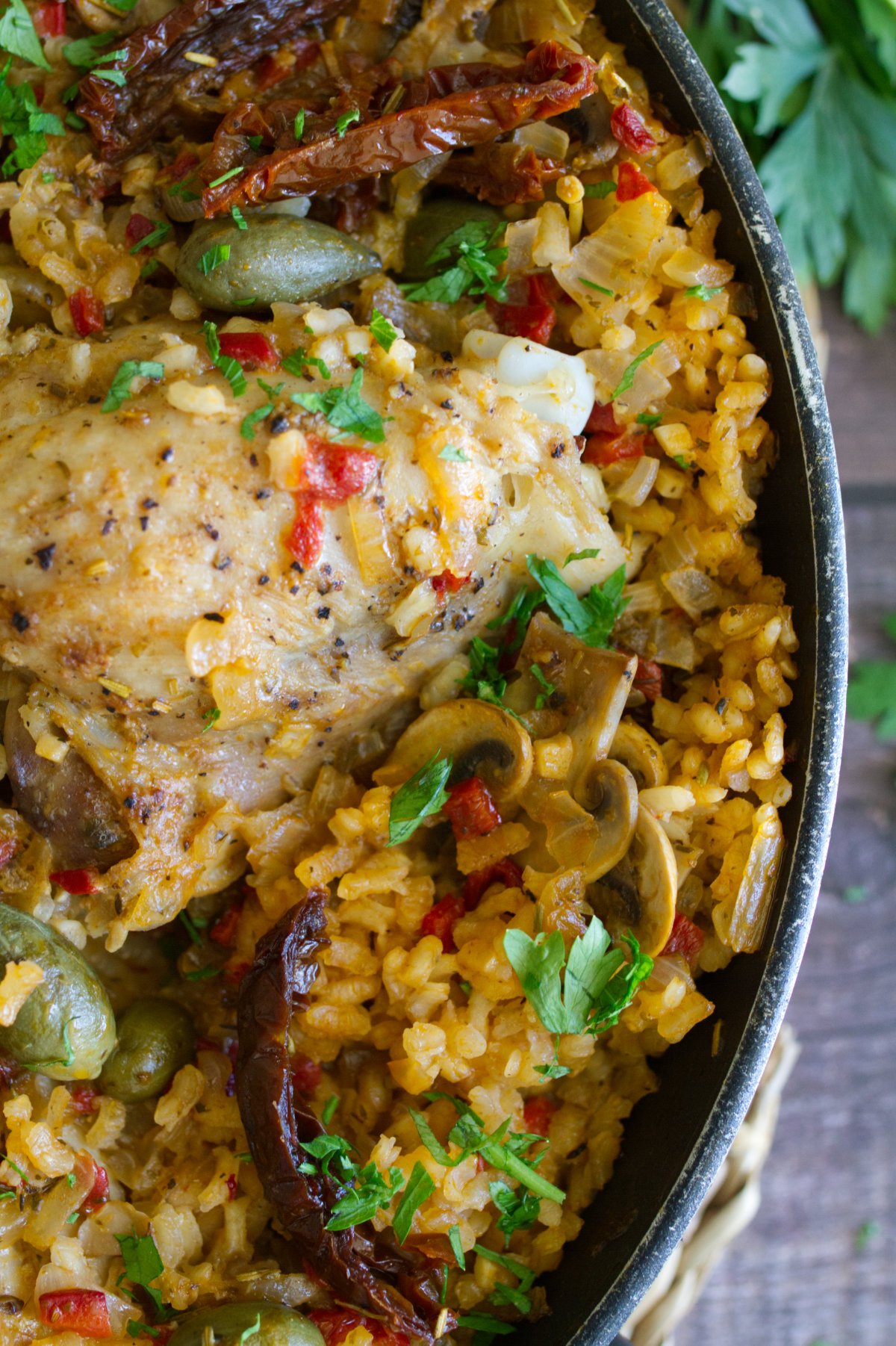 A large pan of Italian Chicken thighs with lots of rice.