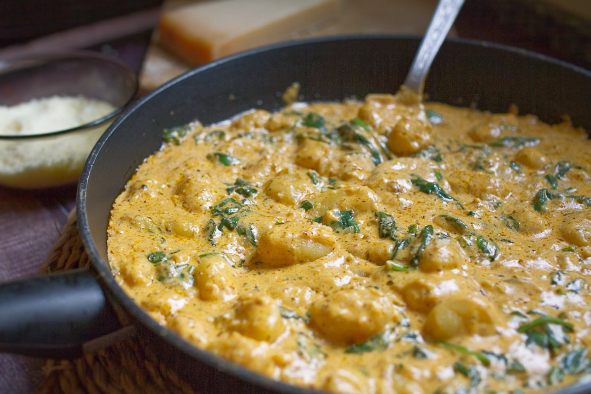 a large pan of creamy gnocchi with parmesan cheese.