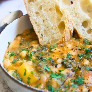 a bowl of white bean soup with some crusty bread slices