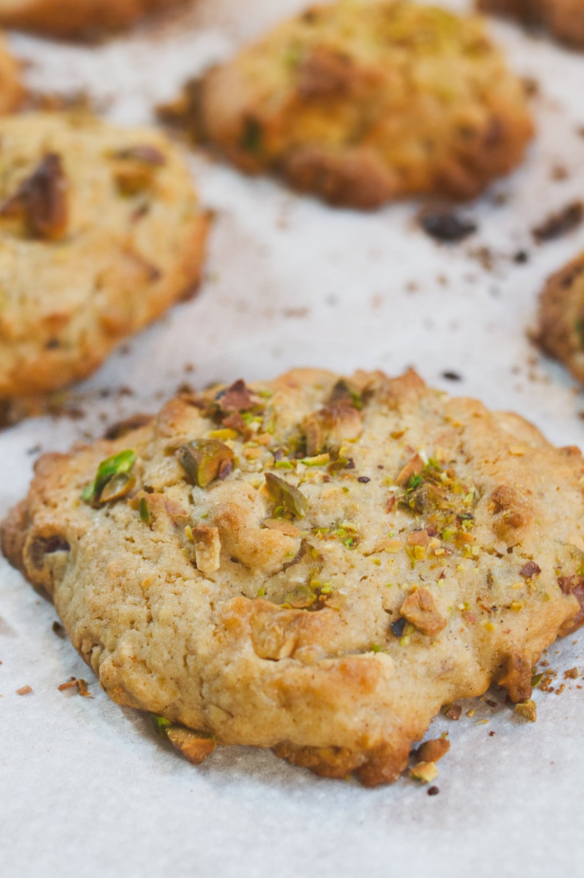 Some white chocolate pistachio cookies sits on a baking rack waiting to cool.