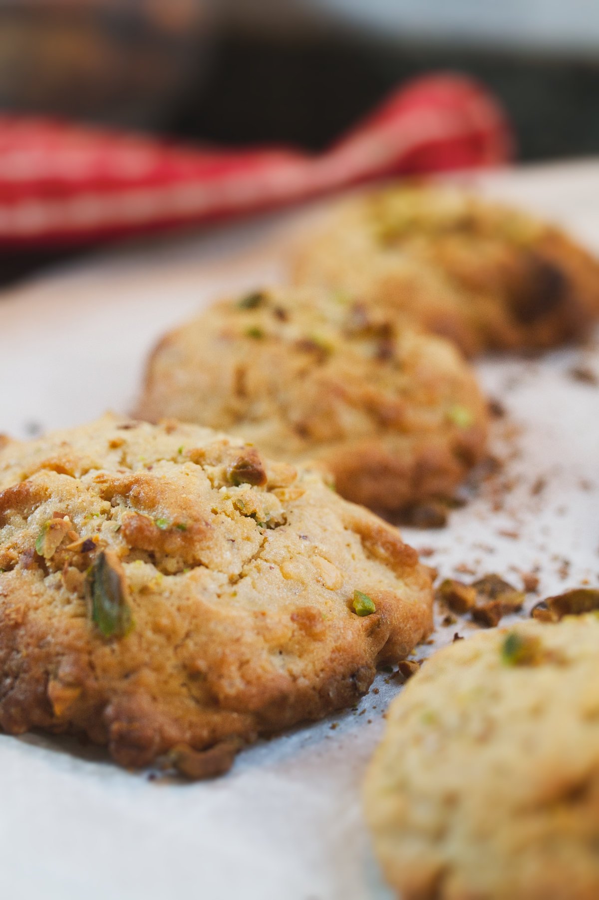 Some white chocolate pistachio cookies sits on a baking rack waiting to cool.