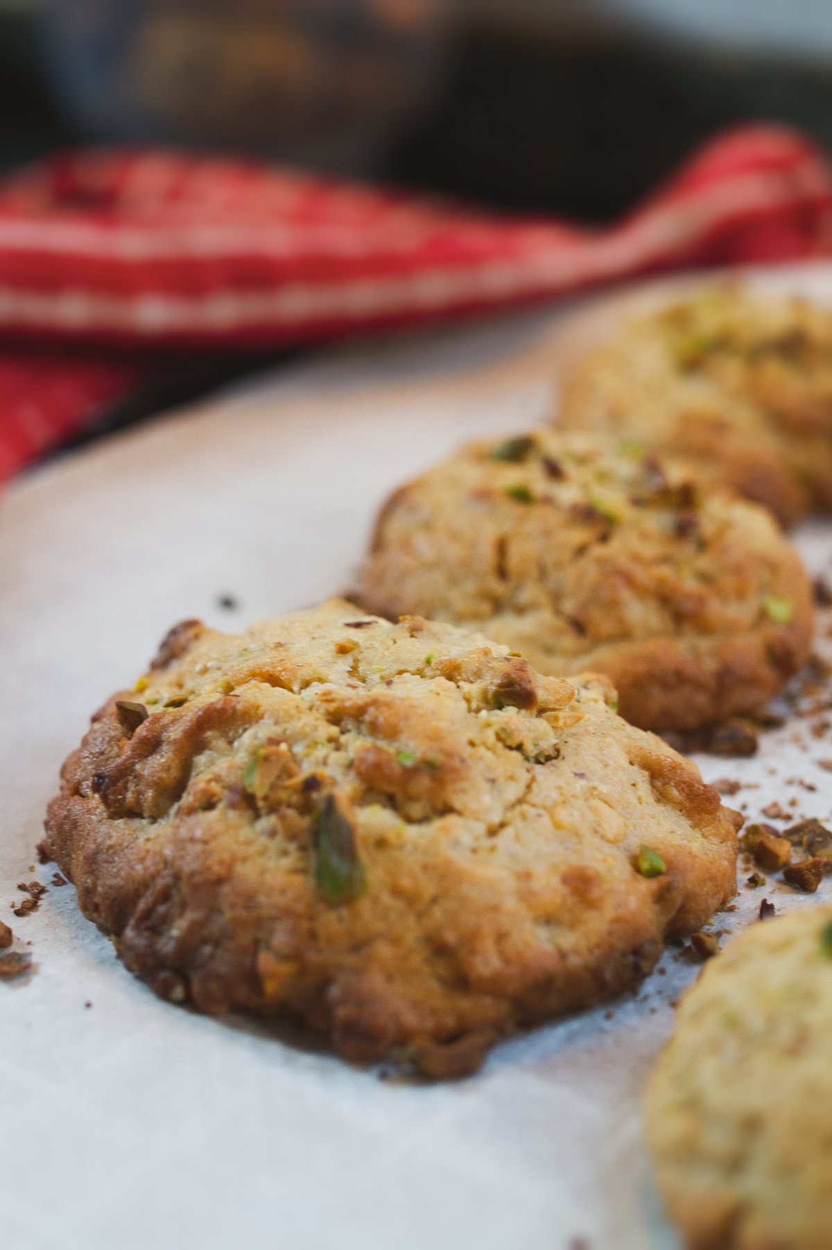 Some white chocolate pistachio cookies sits on a baking rack waiting to cool.