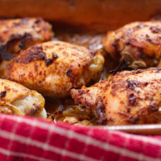 A large pan of cooked spicy Mediterranean chicken thighs