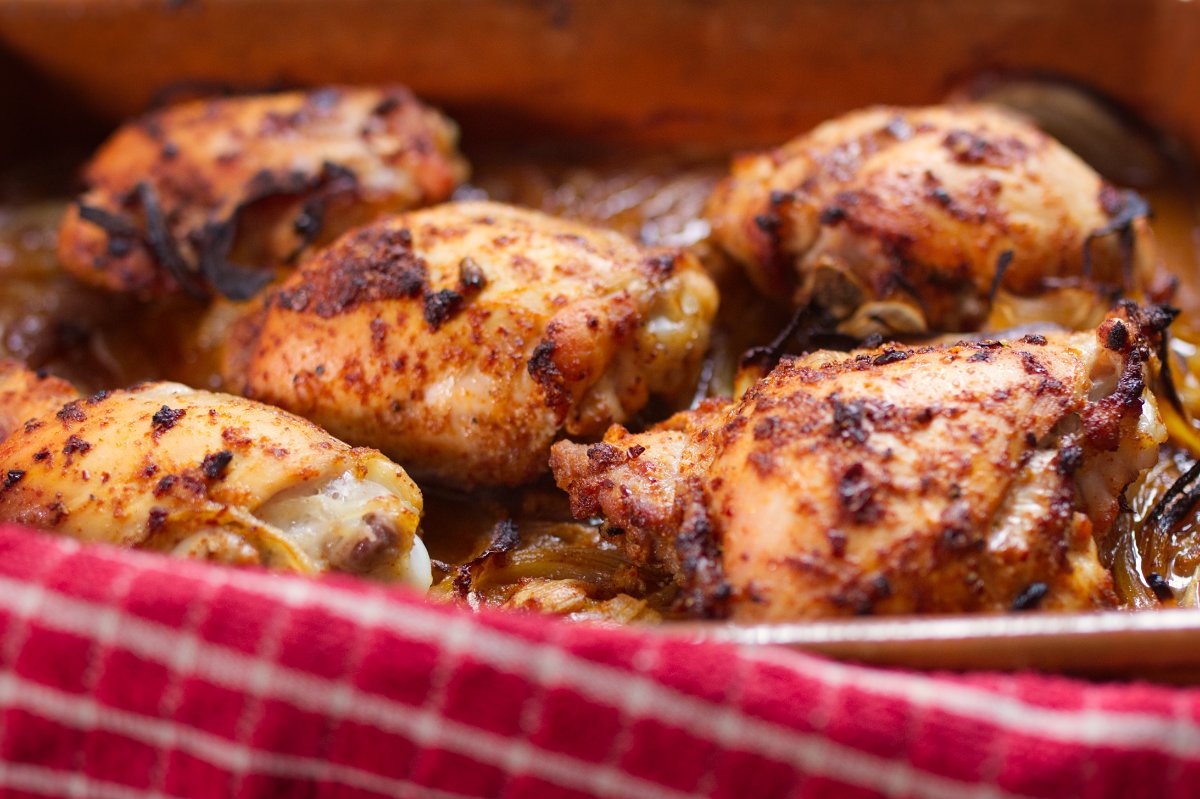 A large pan of cooked spicy Mediterranean chicken thighs