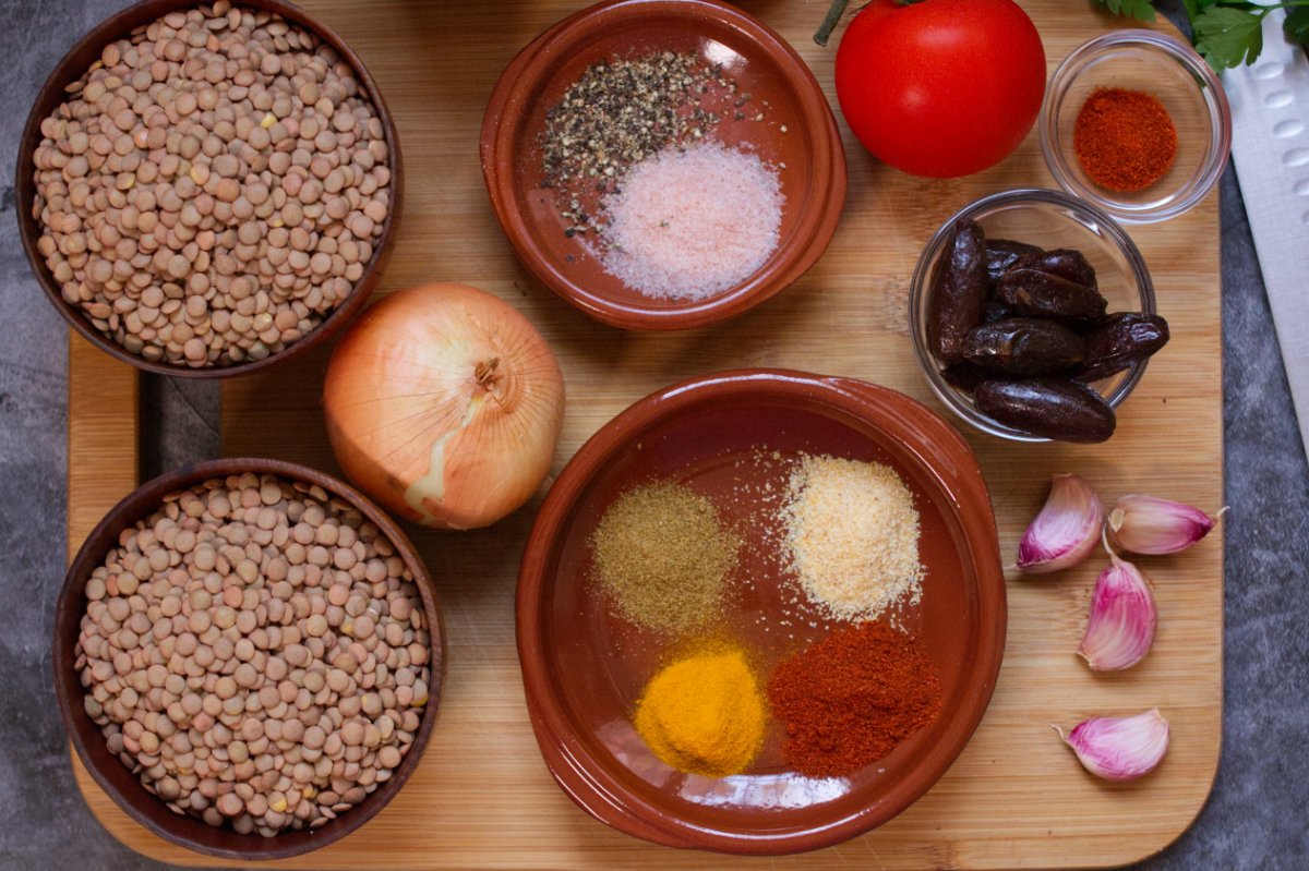 Ingredients used to make Moroccan lentils are laid out on a chopping board