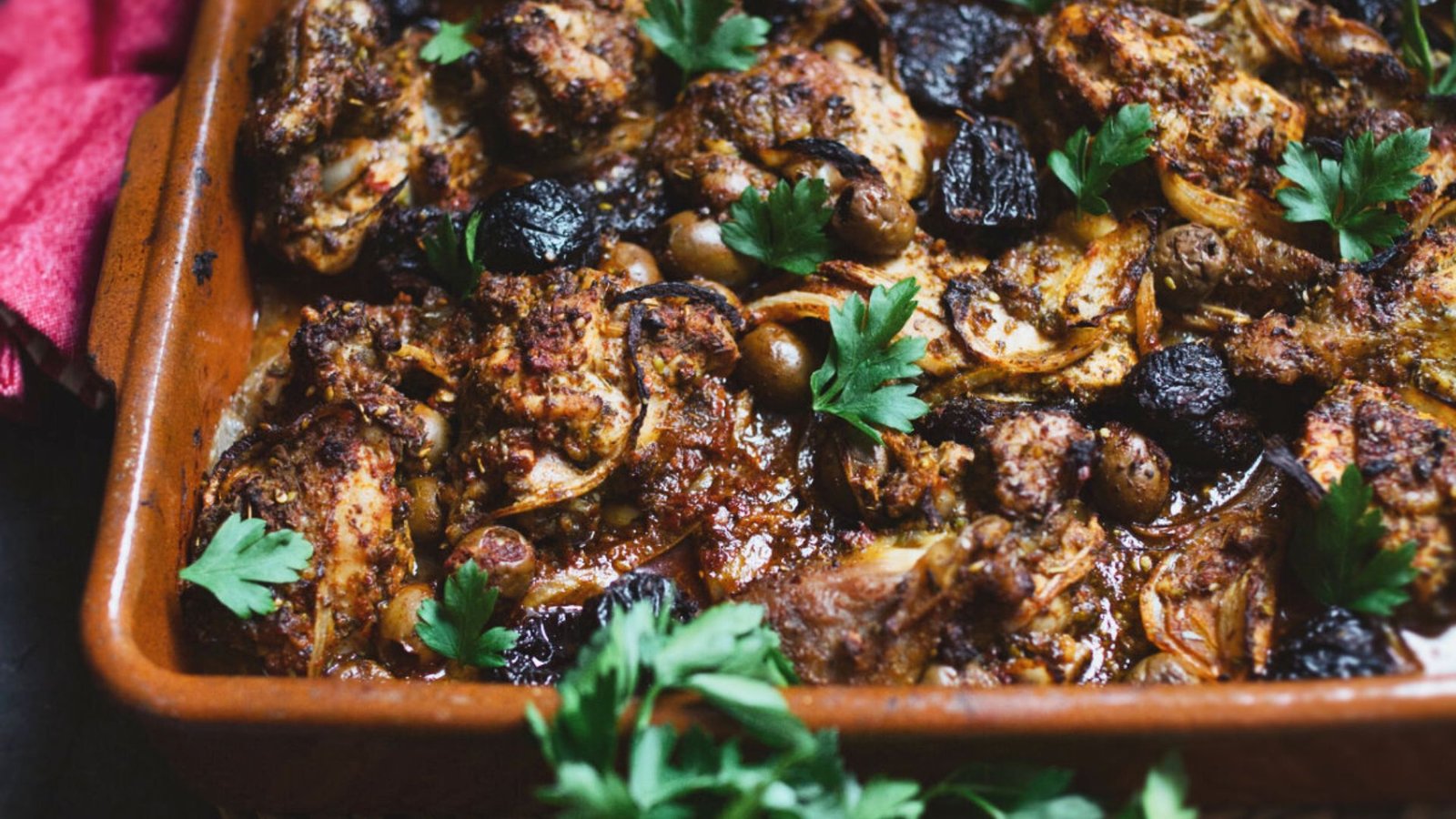 a large dish of za'atar chicken thighs with olives and prunes