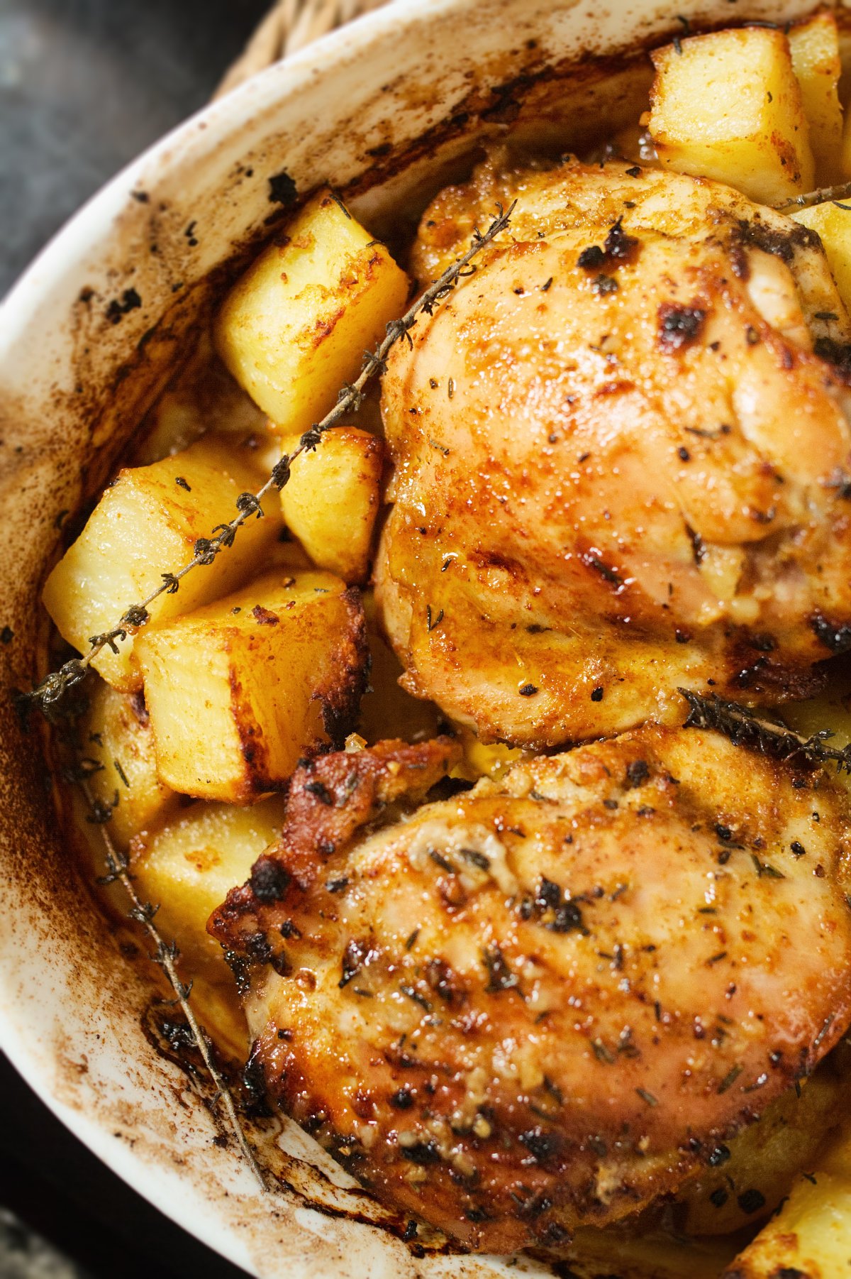 A large pan of chicken and potatoes with lemon and thyme