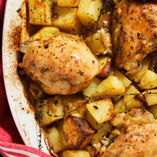 A large pan of chicken and potatoes with lemon and thyme