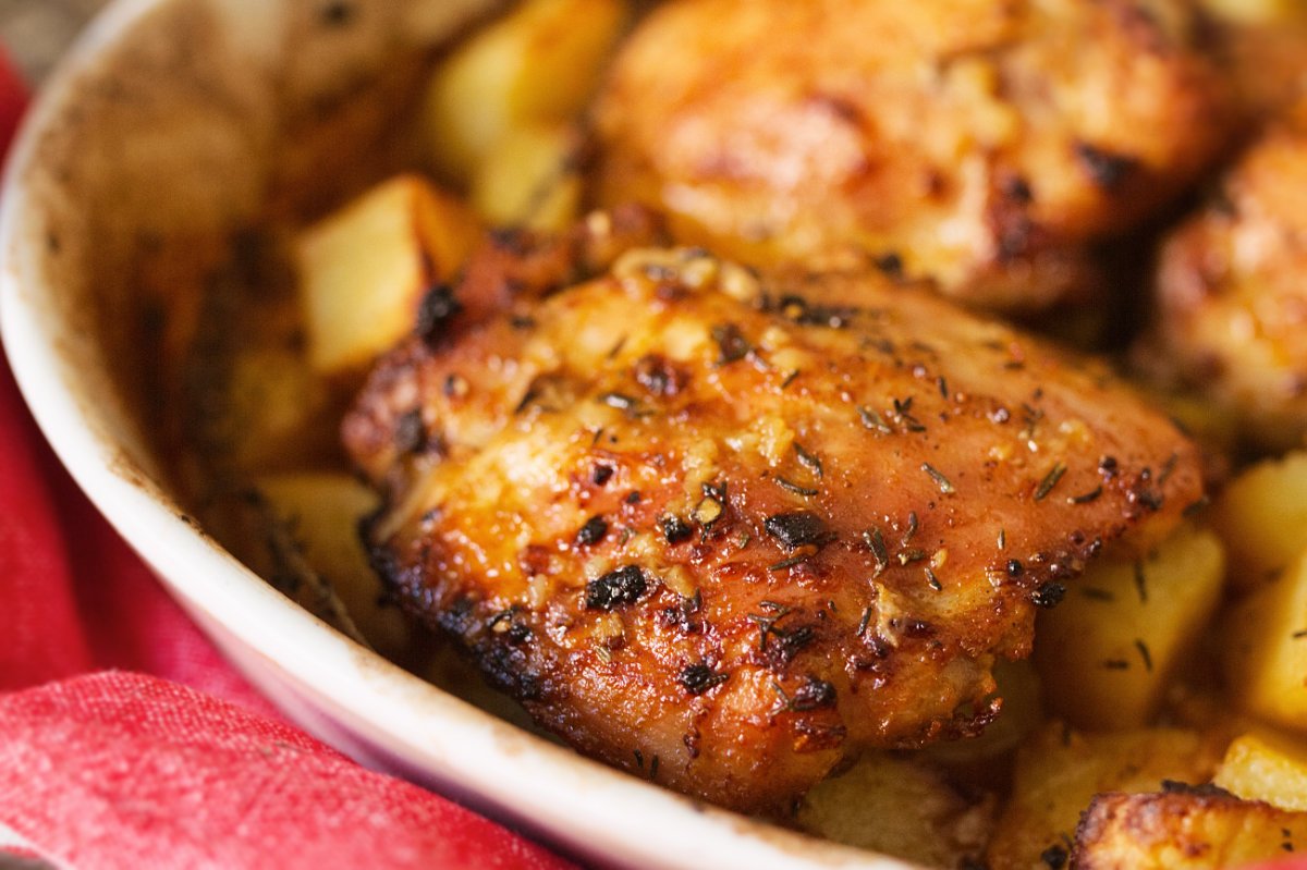 A large pan of chicken and potatoes with lemon and thyme