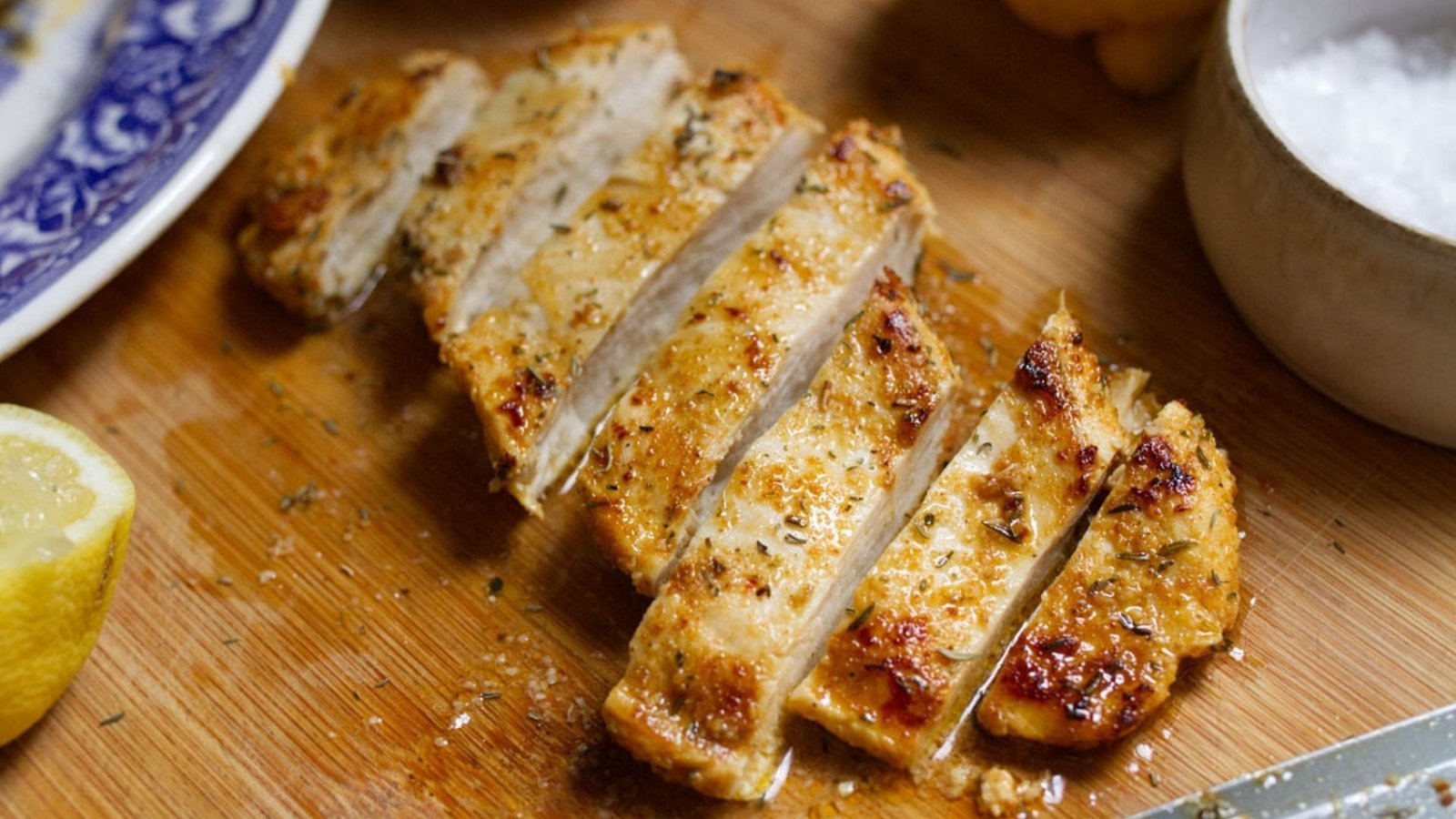 A marinated chicken breast a sliced on a chopping board