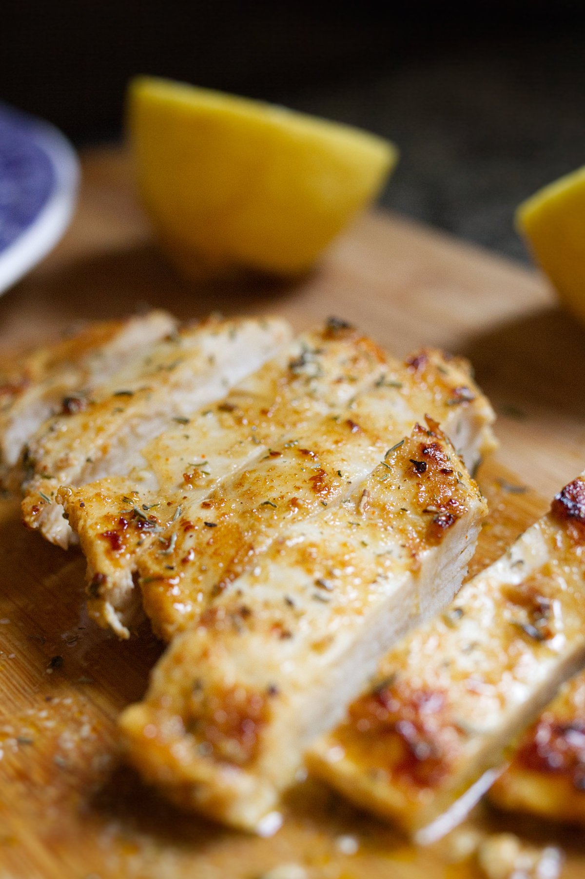 A marinated chicken breast a sliced on a chopping board