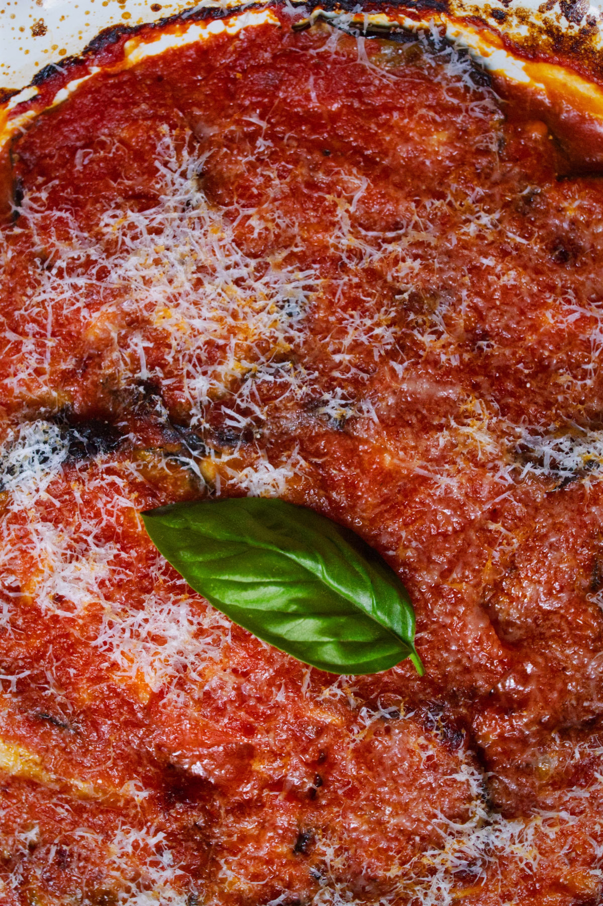 Eggplant-Parmigiana-v14 - happymediterranean.com a large dish of Traditional Italian Melanzane alla Parmigiana (Eggplant Parmesan).