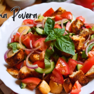 A plate of panzanella salad with cucina povera written over it.