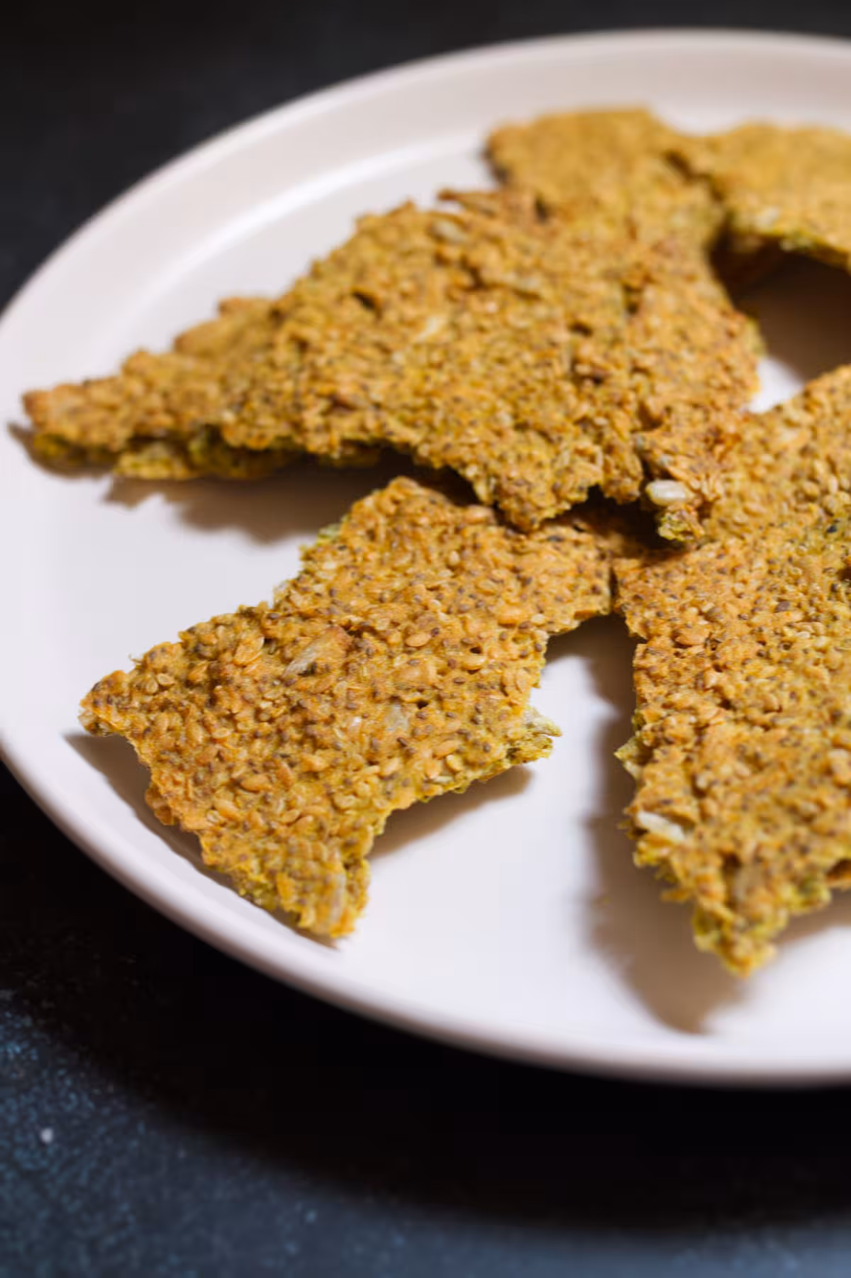 Healthy seed crackers - happymediterranean.com Seed crackers sitting on a plate, ready to serve.