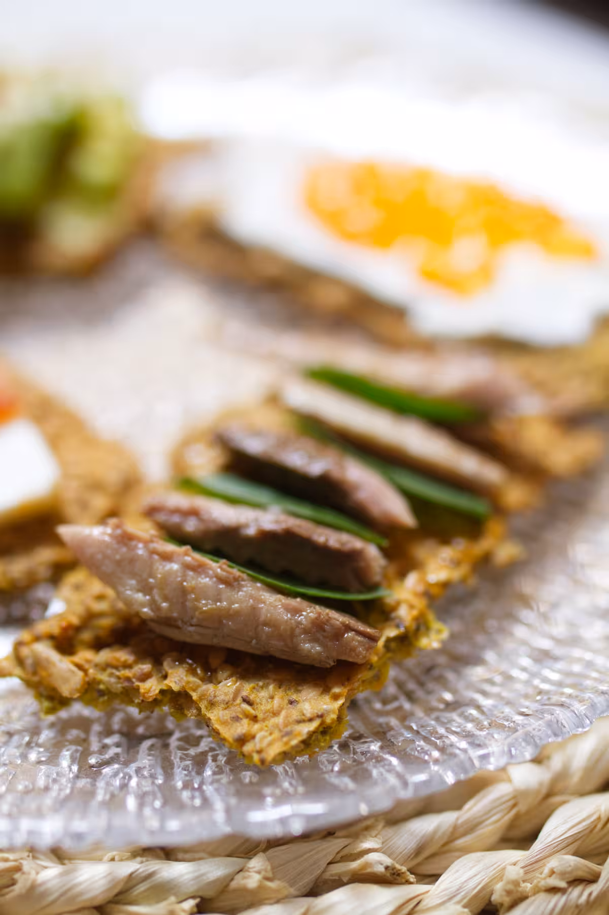 Homemade seed crackers - happymediterranean.com Pieces of tinned mackerel and basil leaves on a cracker.