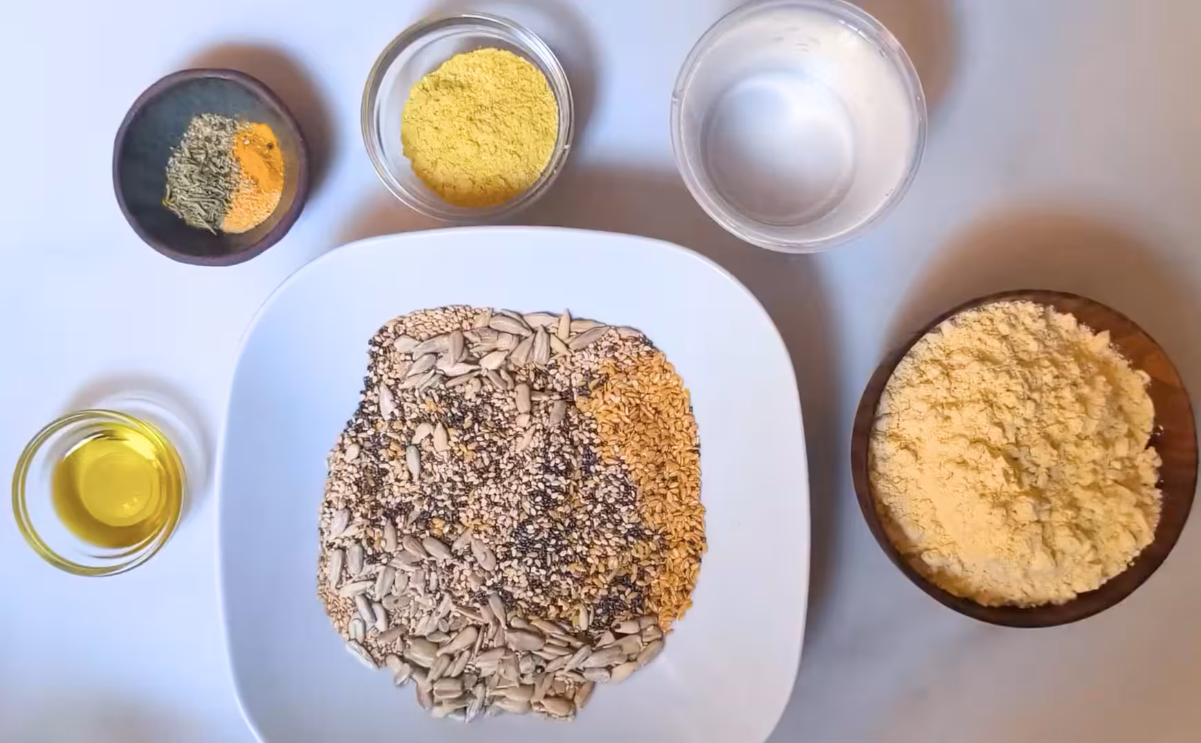 Homemade seed cracker ingredients - happymediterranean.com The raw ingredients laid out in bowls for seed crackers.